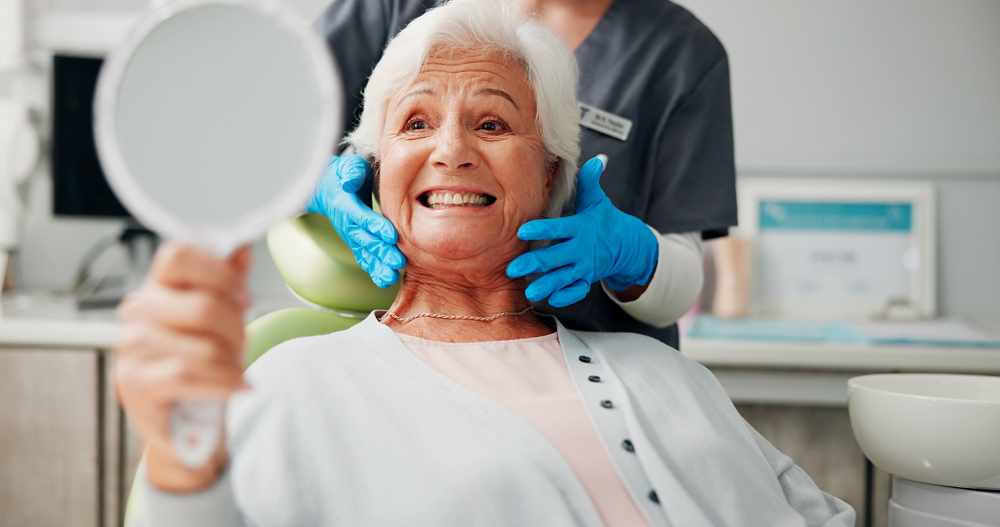 dentist senior woman happy with mirror tooth cleaning results dental implant filling retirement healthcare doctor with elderly patient clinic dentures root canal treatment